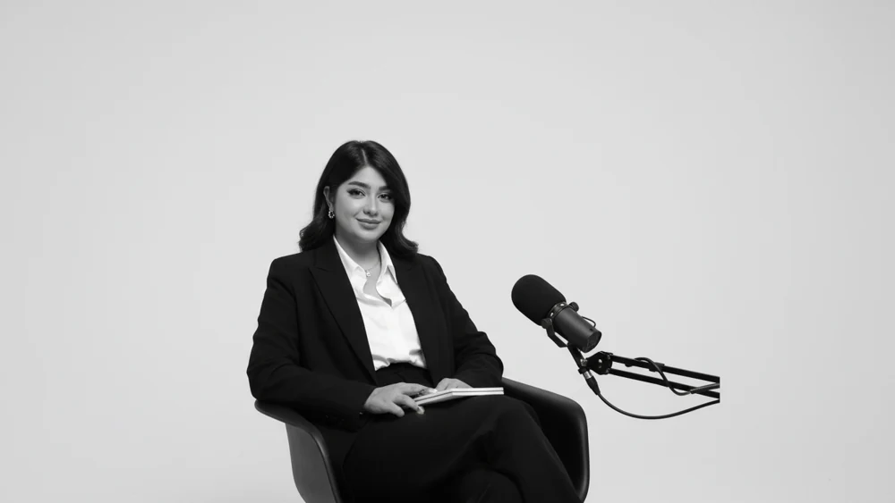 Zahra seated beside a studio microphone